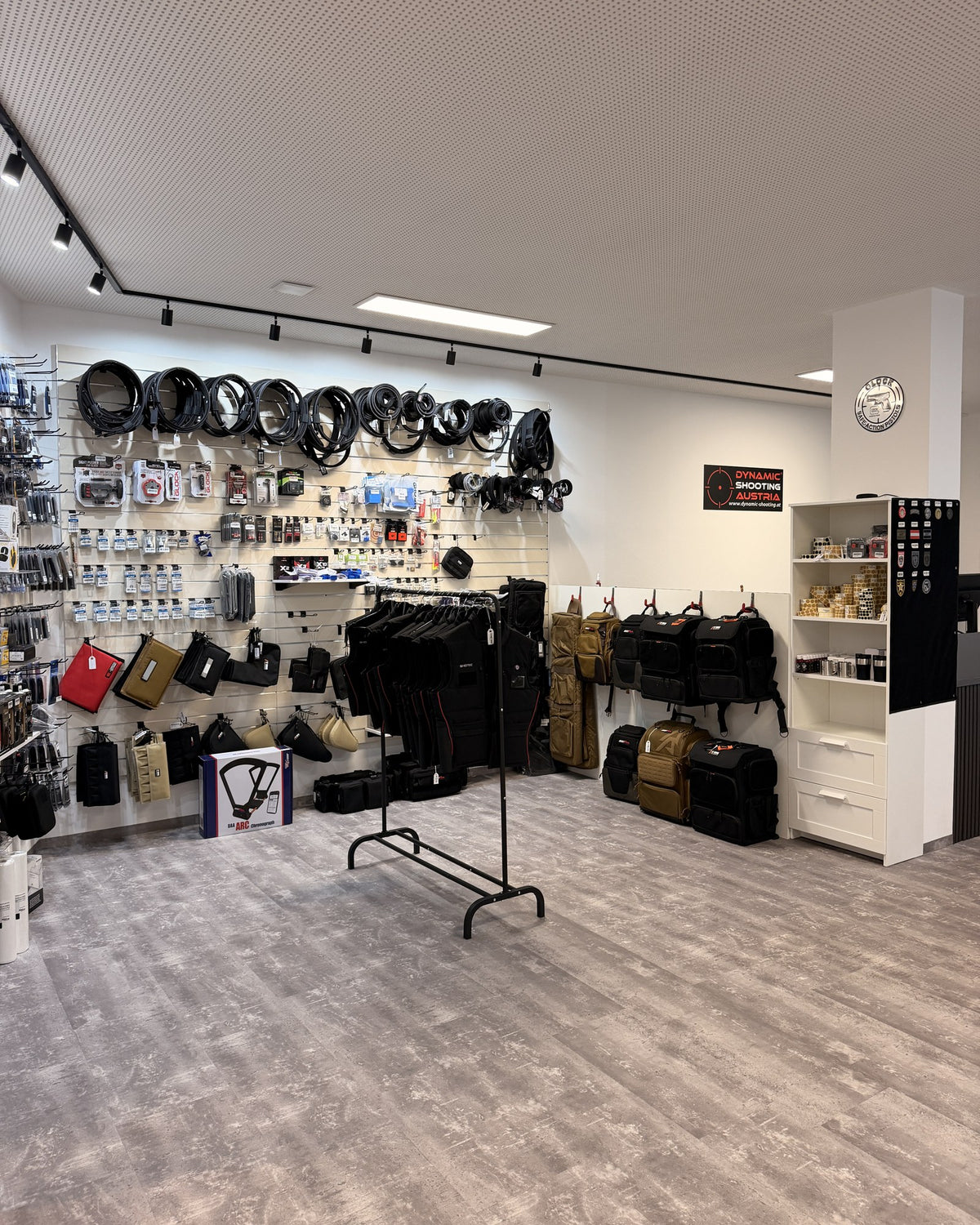 Wall with holsters, belts and backpacks in the Dynamic Shooting Austria store