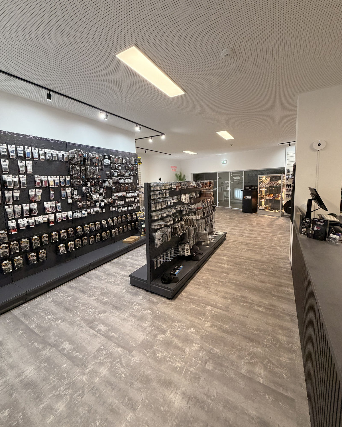 View through the 90 m² sales floor of Dynamic Shooting Austria with shelving walls and sales counter